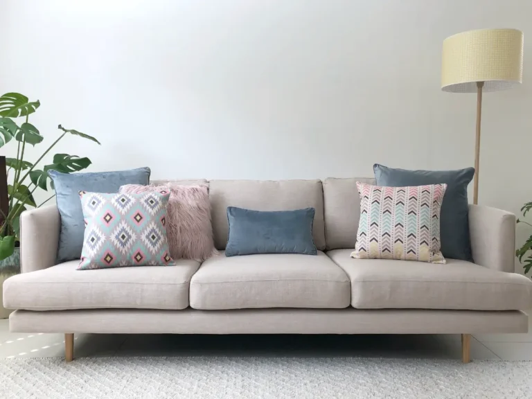 Grey sofa with pastel cushions in pink, grey and blue