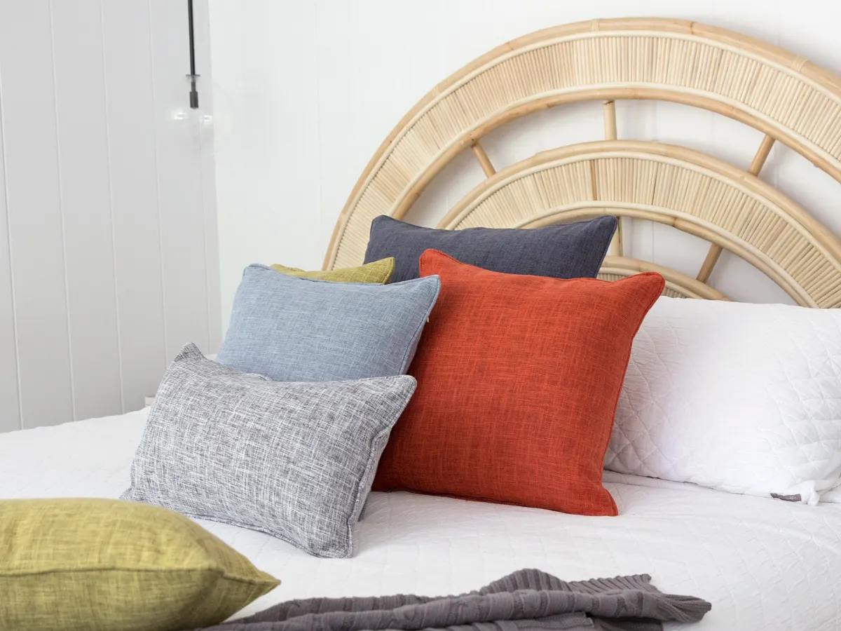 A decorated scene is shown with a neat cushion arrangement on bedding.