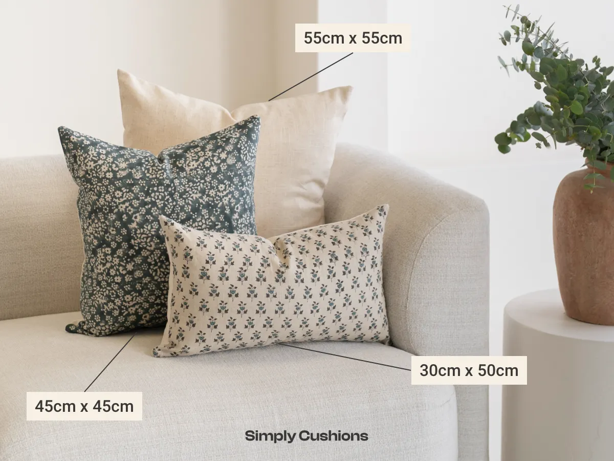 3 styled cushions on a couch with labelled sizes for each design.