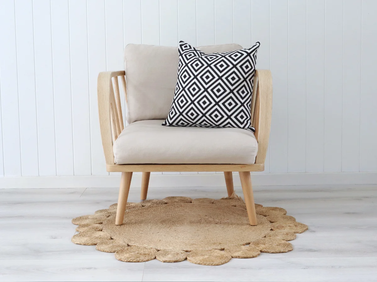 One black and white cushion has been used on an armchair and features a geometric pattern.