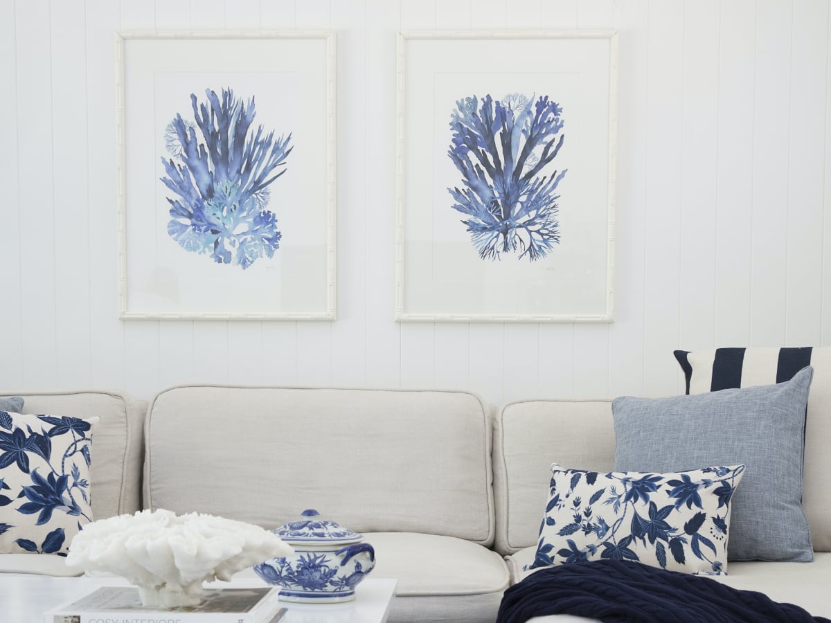 A white wall featuring some Hamptons artwork.