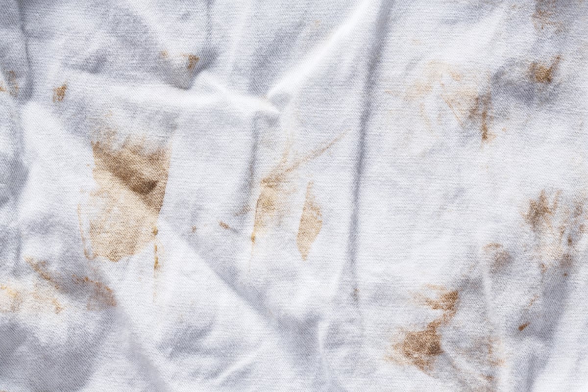 Oily stains on a cushion cover with non-removable cover.