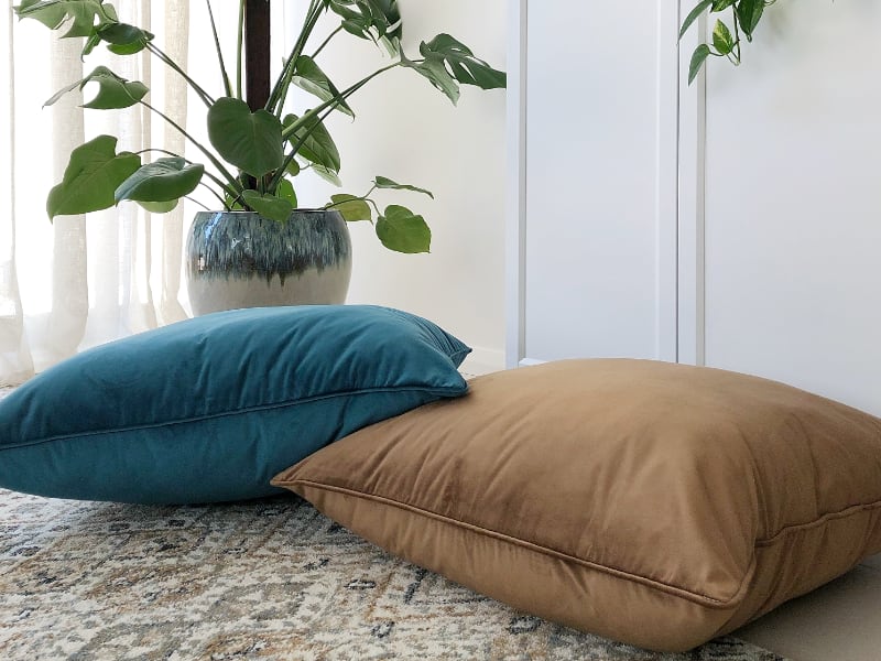 Brown cushions styled on floor and teamed with teal designs