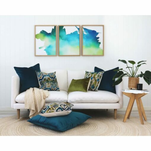 Ikat cushions in olive and teal on a white sofa with floor cushions and Ikat wall art