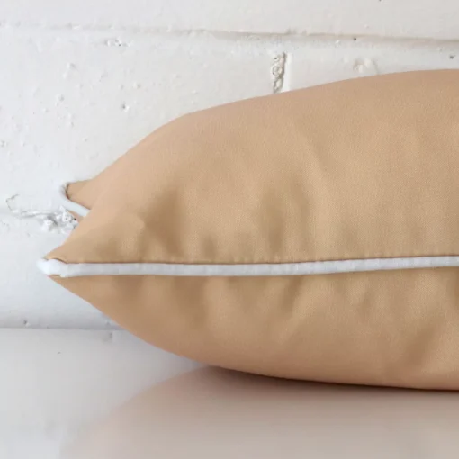 The edge of this outdoor rectangle cushion in beige is shown. The shot shows the front and rear panels.