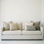 Darcy cushions displayed on sofa with soft beige, grey and check patterned cushions.