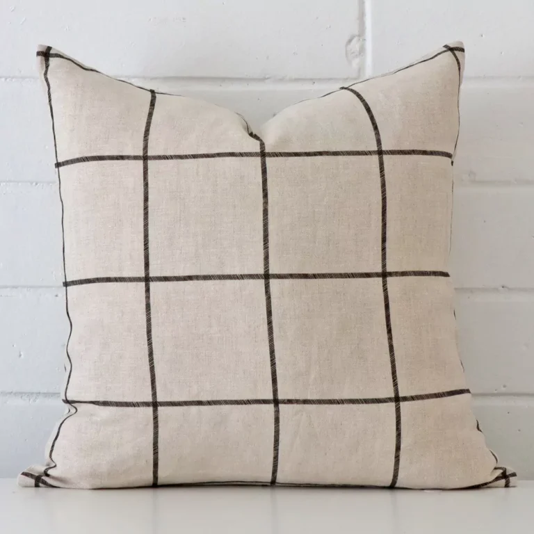 Very close photo of check cushion. The shot shows the linen material and square dimensions with more clarity.