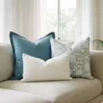 Eva cushions arranged on sofa with blue, grey floral and white textured styles.