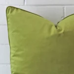 The corner of this velvet square cushion cover is shown close up. The design and green velvet colour are shown in greater detail.