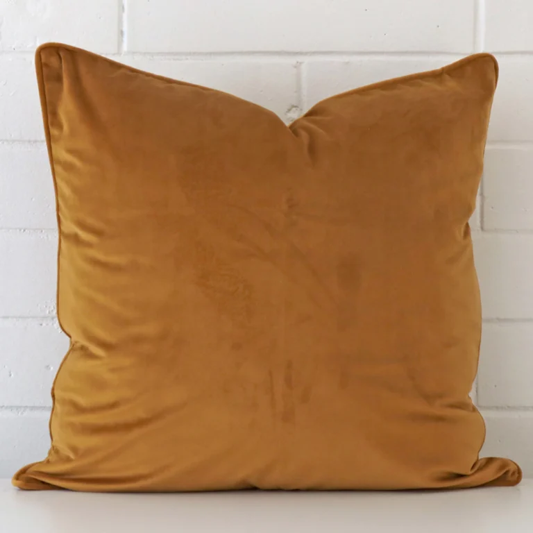 An eye-catching velvet square cushion cover featuring a hue that is honey mustard.