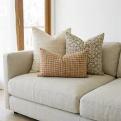 Hunter cushions on sofa with beige stripe, gingham and intricate floral patterns.