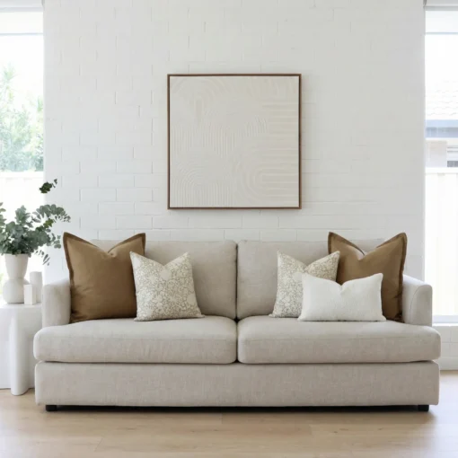Lily cushions styled on sofa with warm brown, beige and textured neutral cushions.