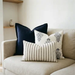 Maya cushions styled on sofa with navy, striped and neutral patterned designs.