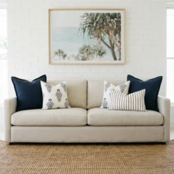 Maya cushions displayed on sofa with navy, white and striped patterned cushions.