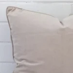 Close up view showing a corner of this velvet cushion in a large size and with natural colouring.
