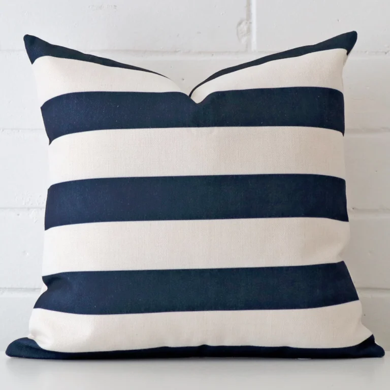 Linen cushion cover features prominently against a white wall. It is a square design and has a striped decorative finish.