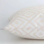 Beige geometric cushion cover laid on its back side. The image shows a side-on view of the outdoor material and its square dimensions.