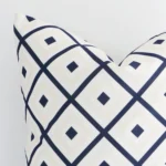Cropped shot of top left corner of this outdoor navy beige cushion cover. This viewpoint shows the outdoor fabric and square shape with more precision.