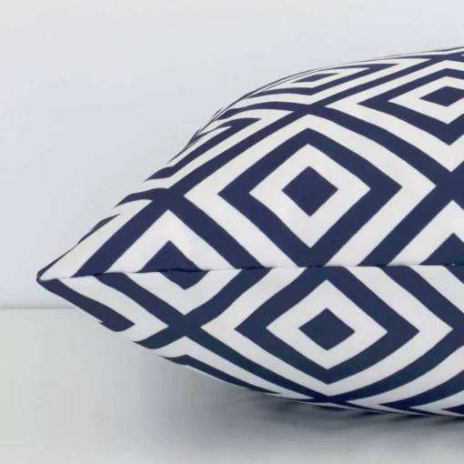 Side edge of geometric square cushion. The outdoor material and navy colour can be seen from this lateral viewpoint.