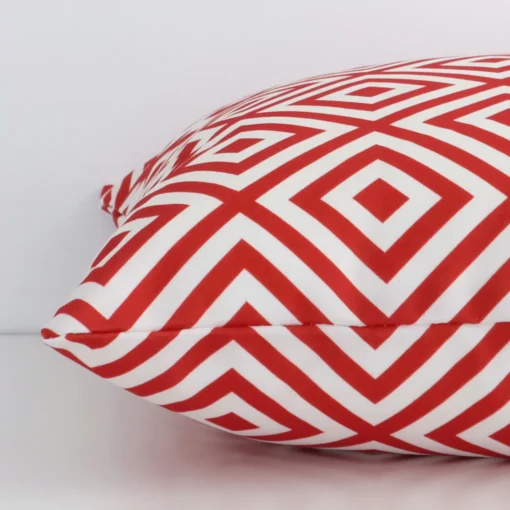 A side view of red geometric cushion that has outdoor fabric and a square size.