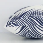Rectangular palm designed cushion cover in navy colour sitting flat. The sideways viewpoint shows the seams of the outdoor material.