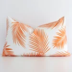 Vibrant orange palm-styled cushion cover constructed from outdoor fabric and shown in a rectangle shape.