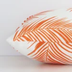 A rectangle orange palm-styled cushion positioned on its back panel. The shot shows a lateral view of the outdoor fabric.