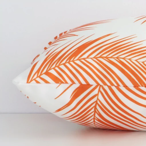 A rectangle orange palm-styled cushion positioned on its back panel. The shot shows a lateral view of the outdoor fabric.