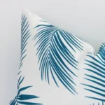 Close up image of top corner of this palm printed teal cushion. This shows the outdoor fabric and its corner up close.