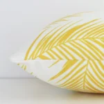 Horizontal edge of palm styled rectangle cushion cover is shown. The outdoor fabric and yellow tone can be seen from this side view.