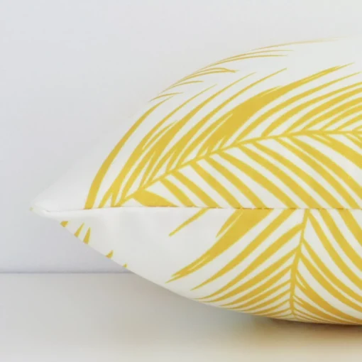 Horizontal edge of palm styled rectangle cushion cover is shown. The outdoor fabric and yellow tone can be seen from this side view.