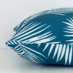 The seams of this outdoor square cushion cover in teal are shown. The image shows the palm design and how the panels are attached.