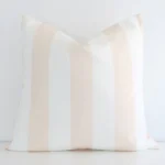 Beige cushion positioned in front of a white wall. It has large dimensions and is made from an outdoor material.