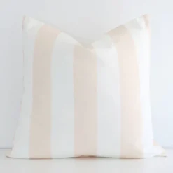 Beige cushion positioned in front of a white wall. It has large dimensions and is made from an outdoor material.