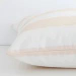 Enlarged image of the side of this beige outdoor cushion. The angle highlights how the large size and palm decorative finish are joined along the seam.