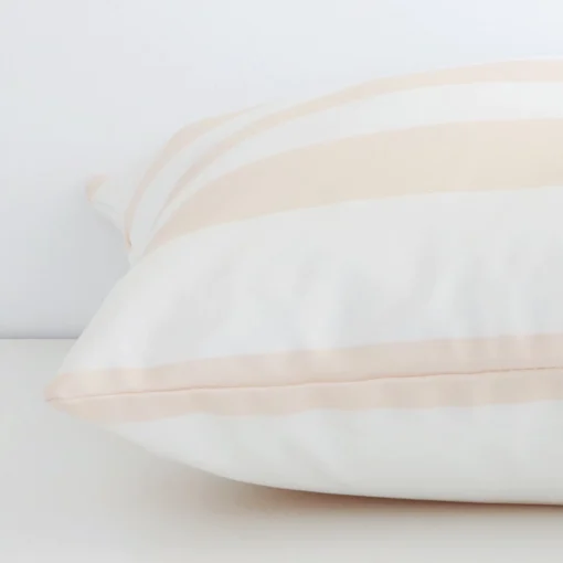 Enlarged image of the side of this beige outdoor cushion. The angle highlights how the large size and palm decorative finish are joined along the seam.