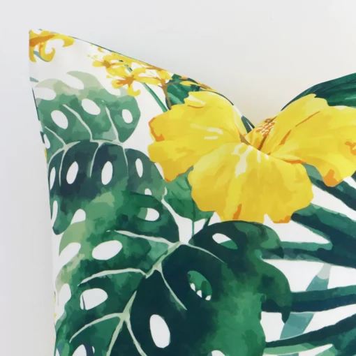 Close range image of yellow floral cushion. The square size and outdoor material can be seen in detail.