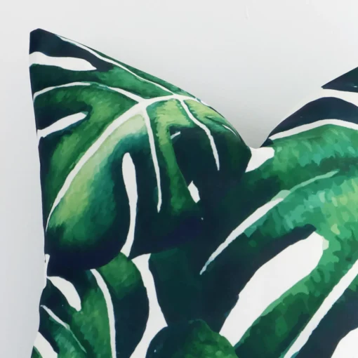 Zoomed photo of the top left corner of this green coloured tropical cushion cover. The image clearly shows the linen material and square dimensions.