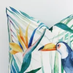 A very close image of the corner of a tropical linen cushion.The finer detail of the square shape and colourful print are visible.