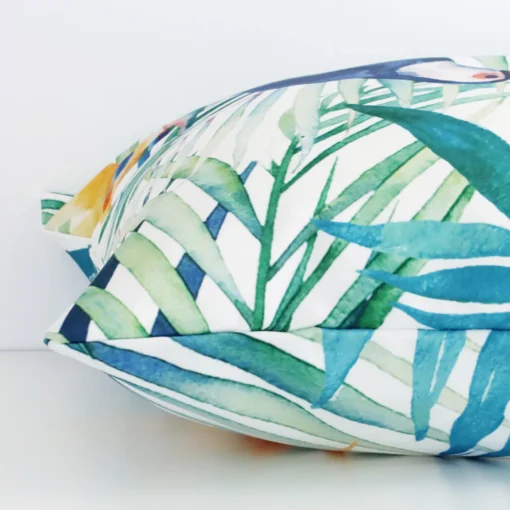 Enlarged image of the side of this colourful linen cushion. The angle highlights how the square design and tropical decorative finish are joined along the seam.