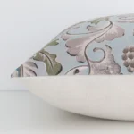 Lateral angle image of a linen square cushion. The colourful print and patterned design are highlighted along its seams.