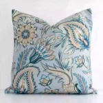 A pretty patterned linen cushion cover is shown against a white wall. It features a square shape and a colourful finish.