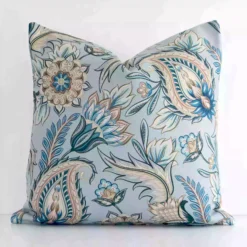 A pretty patterned linen cushion cover is shown against a white wall. It features a square shape and a colourful finish.