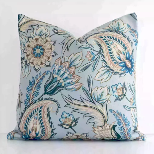 A pretty patterned linen cushion cover is shown against a white wall. It features a square shape and a colourful finish.