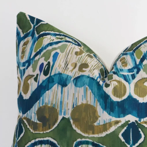 A close up shot showing the top left side of this square linen cushion cover. The colourful tone and patterned design are magnified.