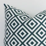 Extreme close up of a square green cushion. The geometric style and outdoor fabric are shown with a much higher degree of detail.