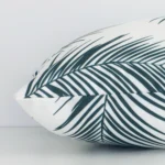 Side shot showing the seam of this rectangle green cushion that features a palm motif on its outdoor material.