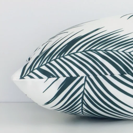 Side shot showing the seam of this rectangle green cushion that features a palm motif on its outdoor material.