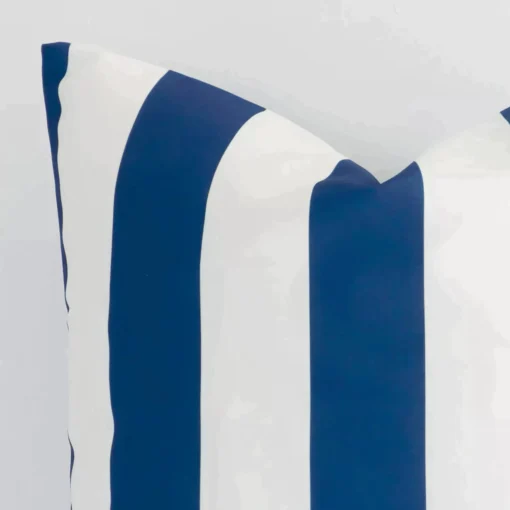 A very close image of the corner of a large outdoor cushion.The finer detail of the shape and navy colour are visible.