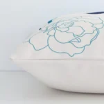 A side shot of a floral linen cushion cover. The angle shows the edge of the square shape and the colourful tone.